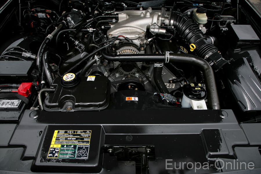 Engine bay of a 2003 Mercury Marauder, showing the V8 engine, battery, and various hoses and components