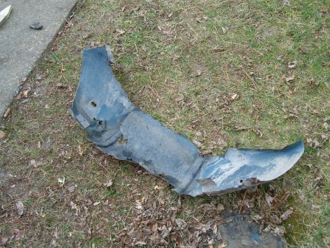 1990 Ford Bronco - This damaged fender liner is a replacement part for a vehicle.