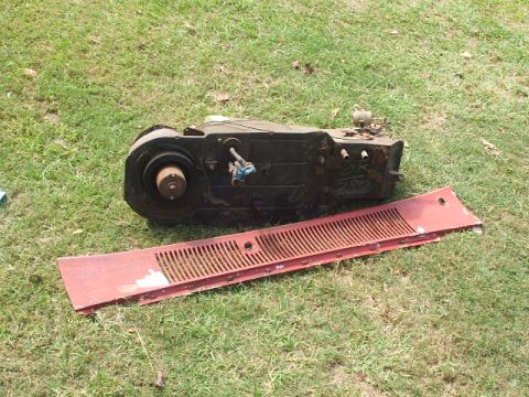 1966 Ford Ranchero - A black heater core and vent assembly sits on the grass next to a red vent grille.
