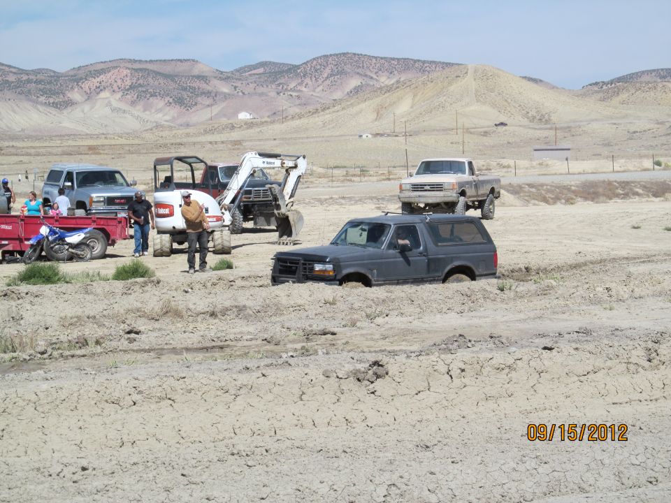 Dark gray Ford Bronco stuck in mud, front end submerged