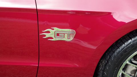2007 Ford Mustang - Close-up of the GT badge on the fender of a red 2007 Ford Mustang.
