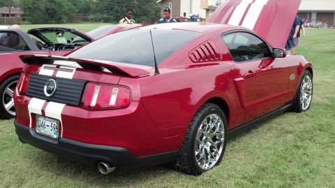 2007 Ford Mustang - Rear view of a red 2007 Ford Mustang GT showing off its racing stripes and chrome wheels.