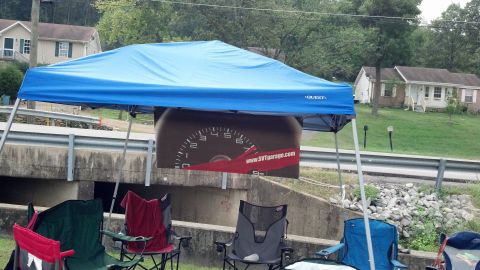 2007 Ford Mustang - A banner displaying a car's speedometer and a website is visible under a blue canopy.