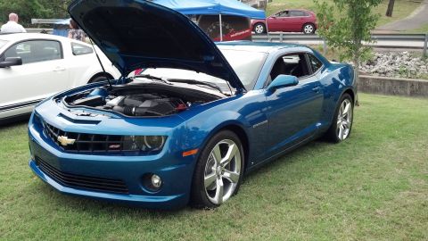 2007 Ford Mustang - A blue Chevrolet Camaro is parked on a grassy area with its hood open, showing the engine.