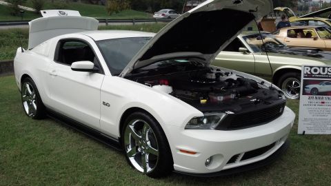 2007 Ford Mustang - A white Ford Mustang is displayed with its hood and trunk open, parked next to other vehicles.