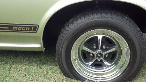 2007 Ford Mustang - Close-up of a classic Mach 1 Mustang's side profile, its iconic decal and a polished chrome wheel.