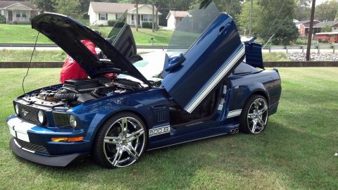 2007 Ford Mustang - This modified 2007 Ford Mustang features custom lambo doors and racing stripes, with the hood open to display the engine.