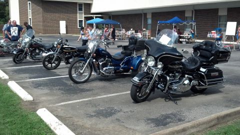 2007 Ford Mustang - A collection of motorcycles are parked in a lot during an outdoor event.