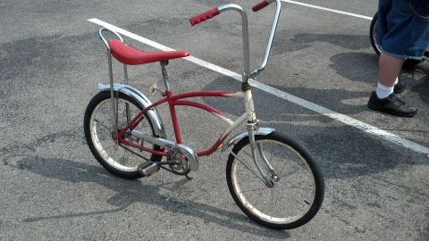 2007 Ford Mustang - Vintage bicycle with red seat and handlebars on a paved surface.