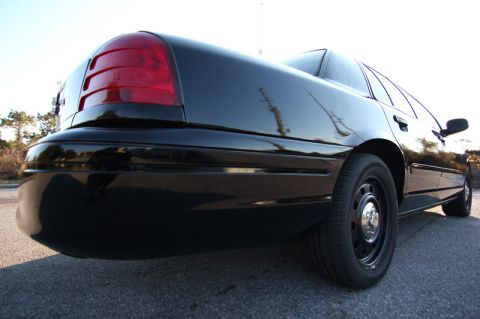 2004 Ford Crown Victoria - Rear view of a black 2004 Ford Crown Victoria showing its taillight and body lines.