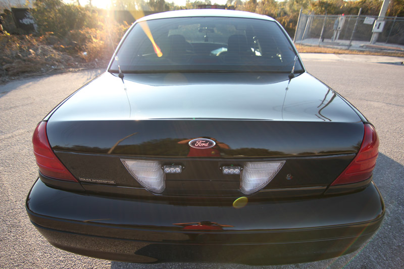 Black 2004 Ford Crown Victoria rear with Ford badge and police lights