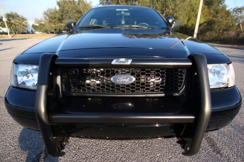 2004 Ford Crown Victoria - This black 2004 Ford Crown Victoria is shown from the front, a protective push bar and a distinctive honeycomb grille.
