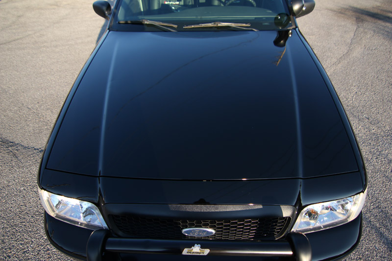 Front view of a black 2004 Ford Crown Victoria Police Interceptor with a push bar