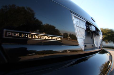 2004 Ford Crown Victoria - Close-up of the rear of a black police vehicle, showing the 'POLICE INTERCEPTOR' badging.