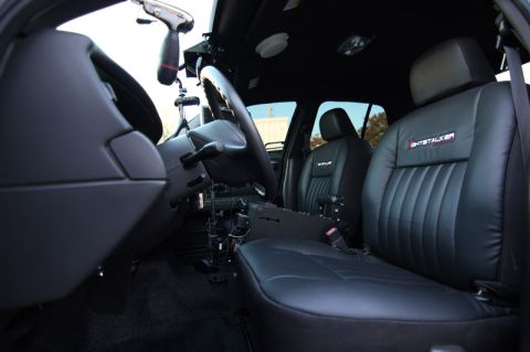 2004 Ford Crown Victoria - The interior of a 2004 Ford Crown Victoria police car, "GHOSTALKER" badging on the seats and a police console.