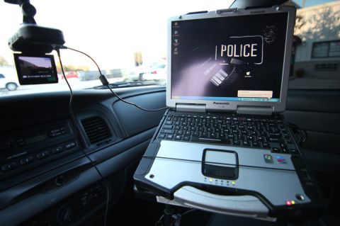 2004 Ford Crown Victoria - Interior view of a 2004 Ford Crown Victoria police car, equipped with a Panasonic Toughbook laptop and a dashcam.