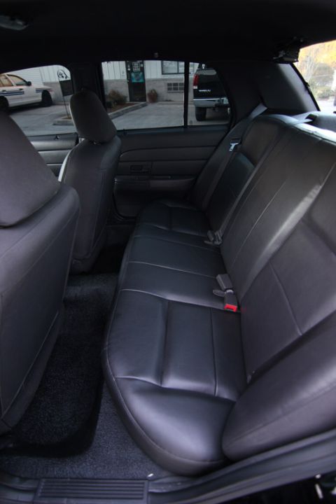 2004 Ford Crown Victoria - Rear interior view of a 2004 Ford Crown Victoria, showing the leather seats and carpeting.