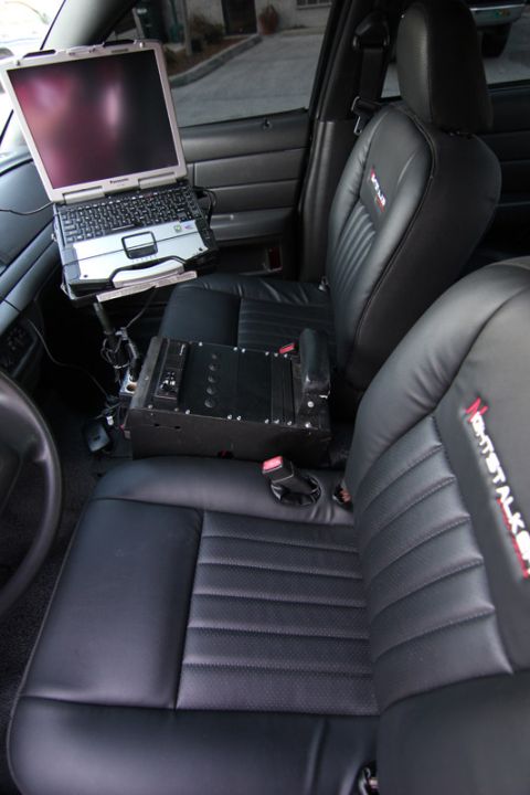2004 Ford Crown Victoria - Interior view of a 2004 Ford Crown Victoria police car with a laptop and console.