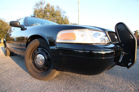 2004 Ford Crown Victoria - A black 2004 Ford Crown Victoria is shown from the front quarter angle, equipped with a push bar.
