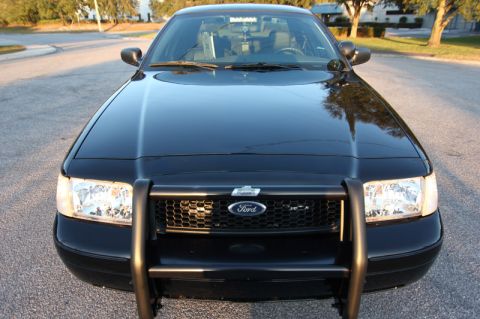2004 Ford Crown Victoria - This black 2004 Ford Crown Victoria Police Interceptor is shown from the front, its distinctive grille and push bar.