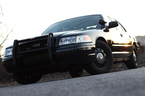 2004 Ford Crown Victoria - Front 3/4 view of a black 2004 Ford Crown Victoria P71 police car with a push bumper.