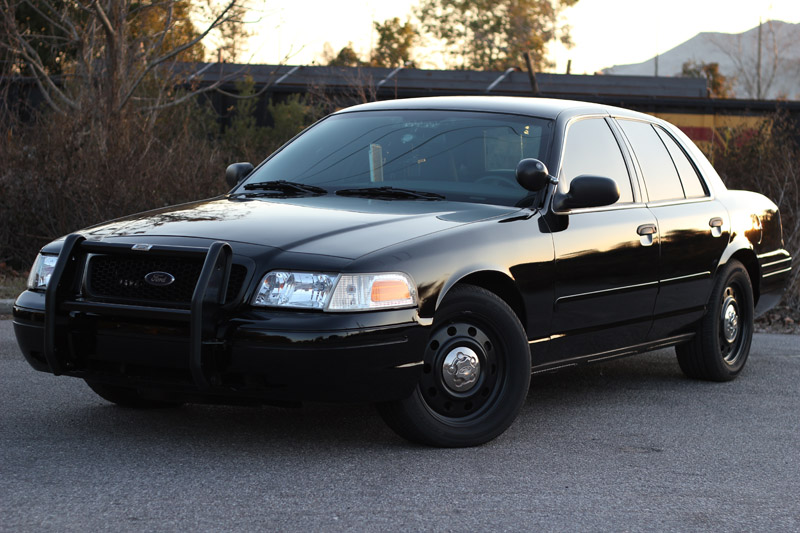 Black 2004 Ford Crown Victoria with a push bar, seen from a 3/4 front angle