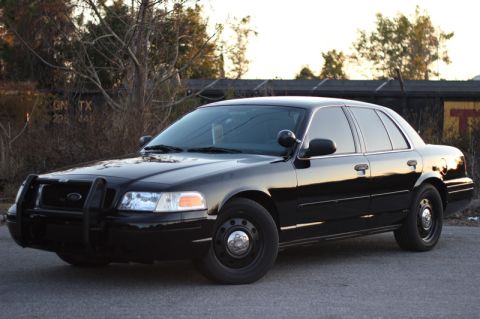 2004 Ford Crown Victoria - A black 2004 Ford Crown Victoria police car is shown from a three-quarter front angle.