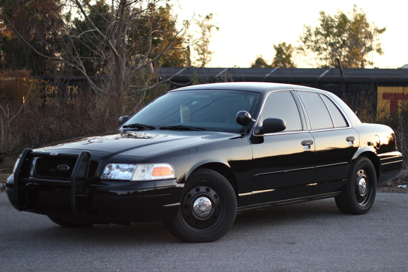 Black 2004 Ford Crown Victoria police car with a push bumper, parked on asphalt