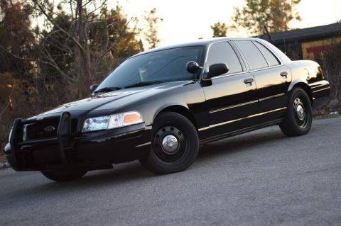 2004 Ford Crown Victoria - This black 2004 Ford Crown Victoria, equipped with a push bar, is captured in a 3/4 front view.