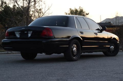 2004 Ford Crown Victoria - Rear three-quarter view of a black 2004 Ford Crown Victoria sedan parked on asphalt.