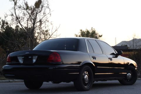 2004 Ford Crown Victoria - Rear view of a black 2004 Ford Crown Victoria sedan parked outdoors.
