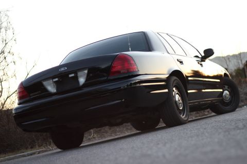 2004 Ford Crown Victoria - Rear view of a black 2004 Ford Crown Victoria sedan parked on a road.