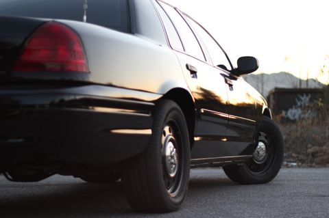 2004 Ford Crown Victoria - Rear view of a black 2004 Ford Crown Victoria, showing its distinctive taillight and body lines.