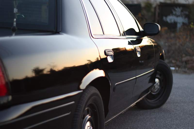 2004 Ford Crown Victoria side view, black paint reflects sunset