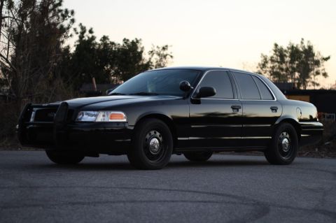 2004 Ford Crown Victoria - A black 2004 Ford Crown Victoria P71 police car is shown from a three-quarter front angle.