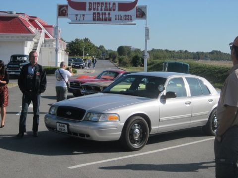 1991 Ford LTD Crown Victoria - A silver Ford Crown Victoria is parked in a lot near a Buffalo Grill restaurant.