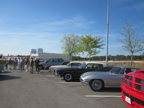 1991 Ford LTD Crown Victoria - Several cars are parked in a lot under a clear blue sky, including a silver sports car in the foreground.