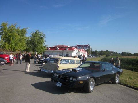 1991 Ford LTD Crown Victoria - A black 1977 Pontiac Firebird Trans Am is parked at a car show with other vehicles and people.