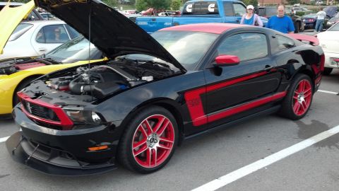2007 Ford Mustang - A black Ford Mustang Boss 302 is parked with its hood open, its engine bay.