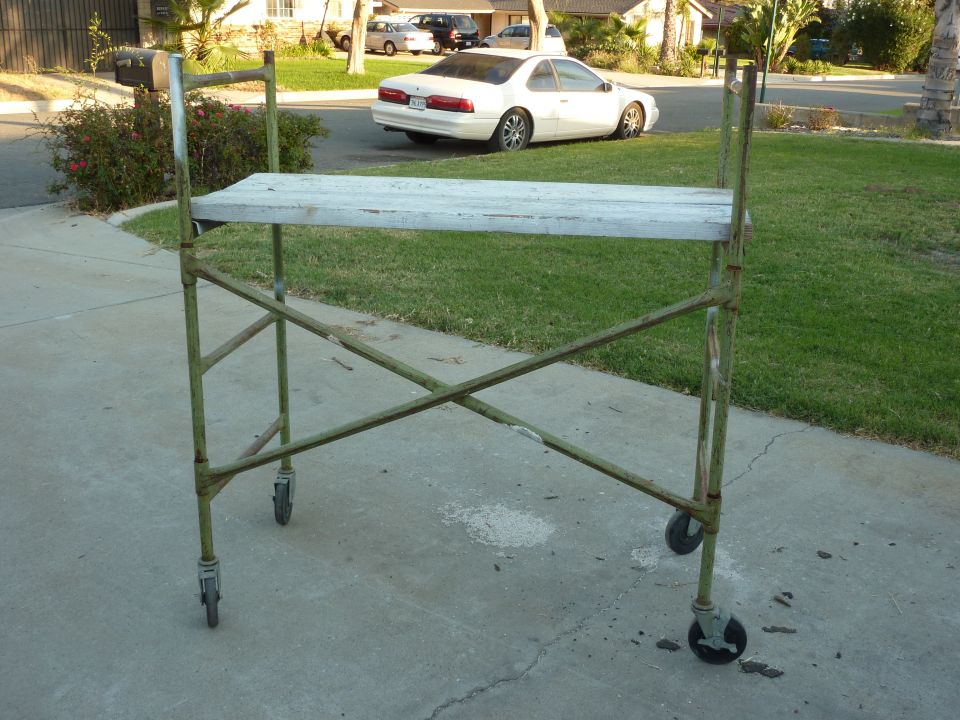 Scaffolding on a driveway with a white coupe in the background