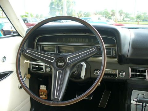 1970 Ford Torino - The interior of a 1970 Ford Torino, a classic wood-rimmed steering wheel and a clear view of the dashboard instrumentation.