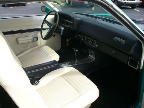 1970 Ford Torino - Interior view of a 1970 Ford Torino, white vinyl seats and a dashboard with wood-grain accents.