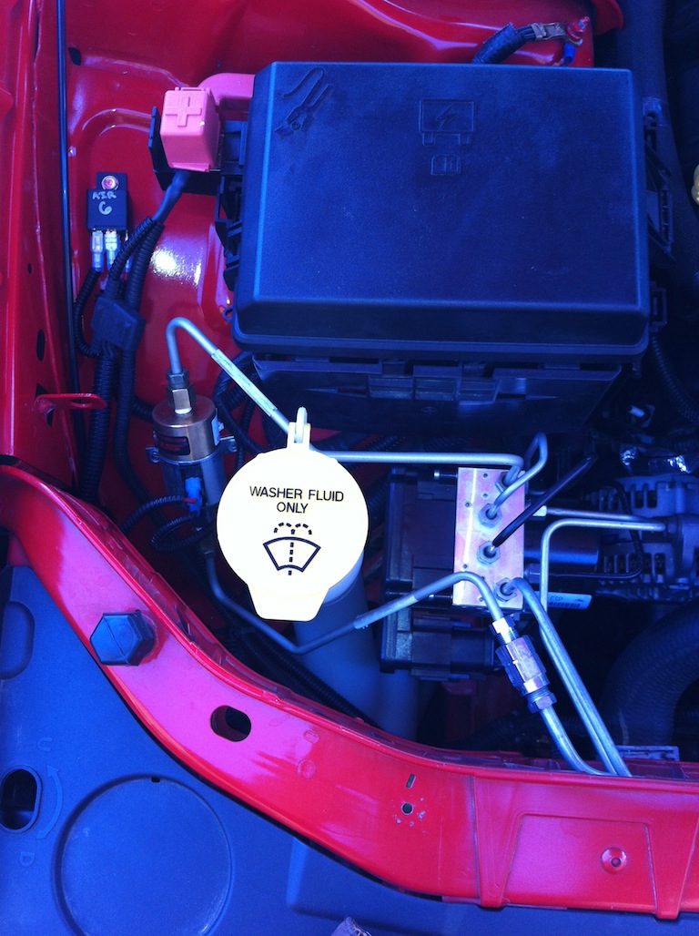 Washer fluid reservoir cap and engine bay components including fuse box and wiring