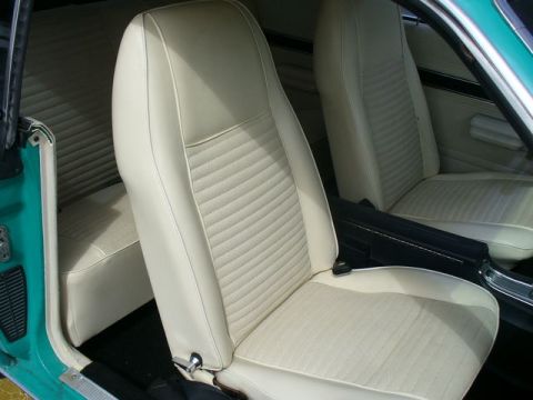 1970 Ford Torino - The interior of a car features light-colored bucket seats with a ribbed pattern and a matching rear bench seat.
