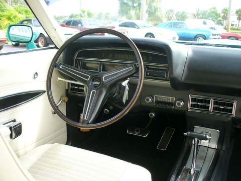 1970 Ford Torino - The interior of a classic Ford Torino features a wood-rimmed steering wheel and a clean dashboard.