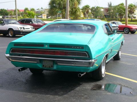 1970 Ford Torino - A teal 1970 Ford Torino is parked in a lot with other vehicles in the background.