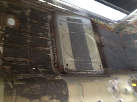 1965 Ford Mustang - Close-up view of a car's interior floor pan, revealing its structural details and condition.