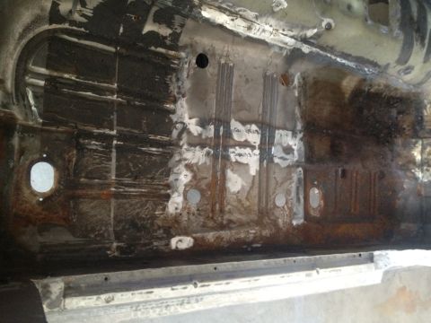 1965 Ford Mustang - Interior view of a heavily rusted and repaired car floor pan.