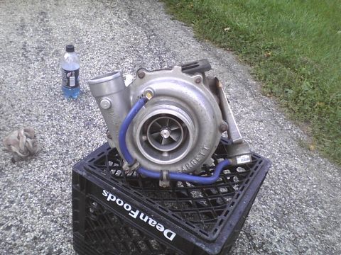 2003 Ford Crown Victoria - A Garrett turbocharger is shown resting on a black milk crate outdoors.