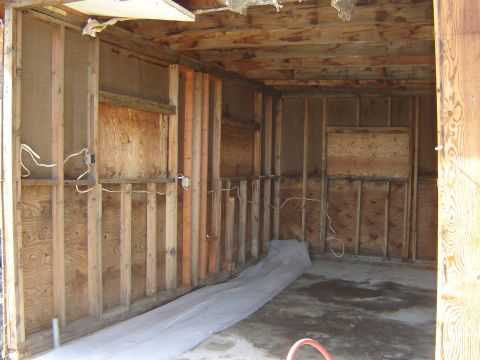 1984 Ford Mustang - Interior view of an unfinished garage space showing construction framing and exposed utilities.